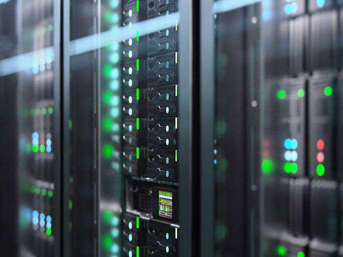 Illuminated rows of cloud server nodes behind glass rack doors, green and blue status LEDs glowing