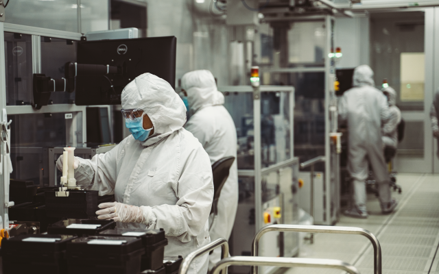 Workers in white cleanroom suits at a Seagate manufacturing inspection line