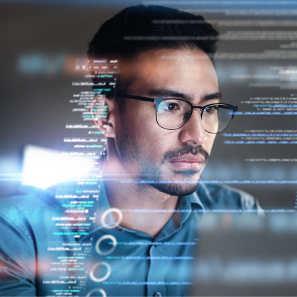Developer in glasses looking at a screen with lines of code overlaid