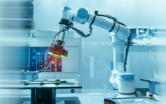 White industrial robotic arm with a green-lit gripper performing automated inspection in a Seagate factory