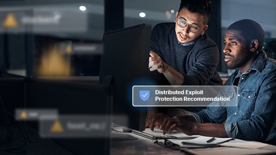 two men looking at a monitor with Distributed Exploit Protection Recommendation text
