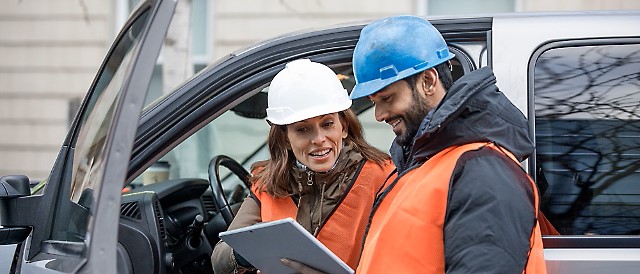 Two engineers discussing something on a tablet