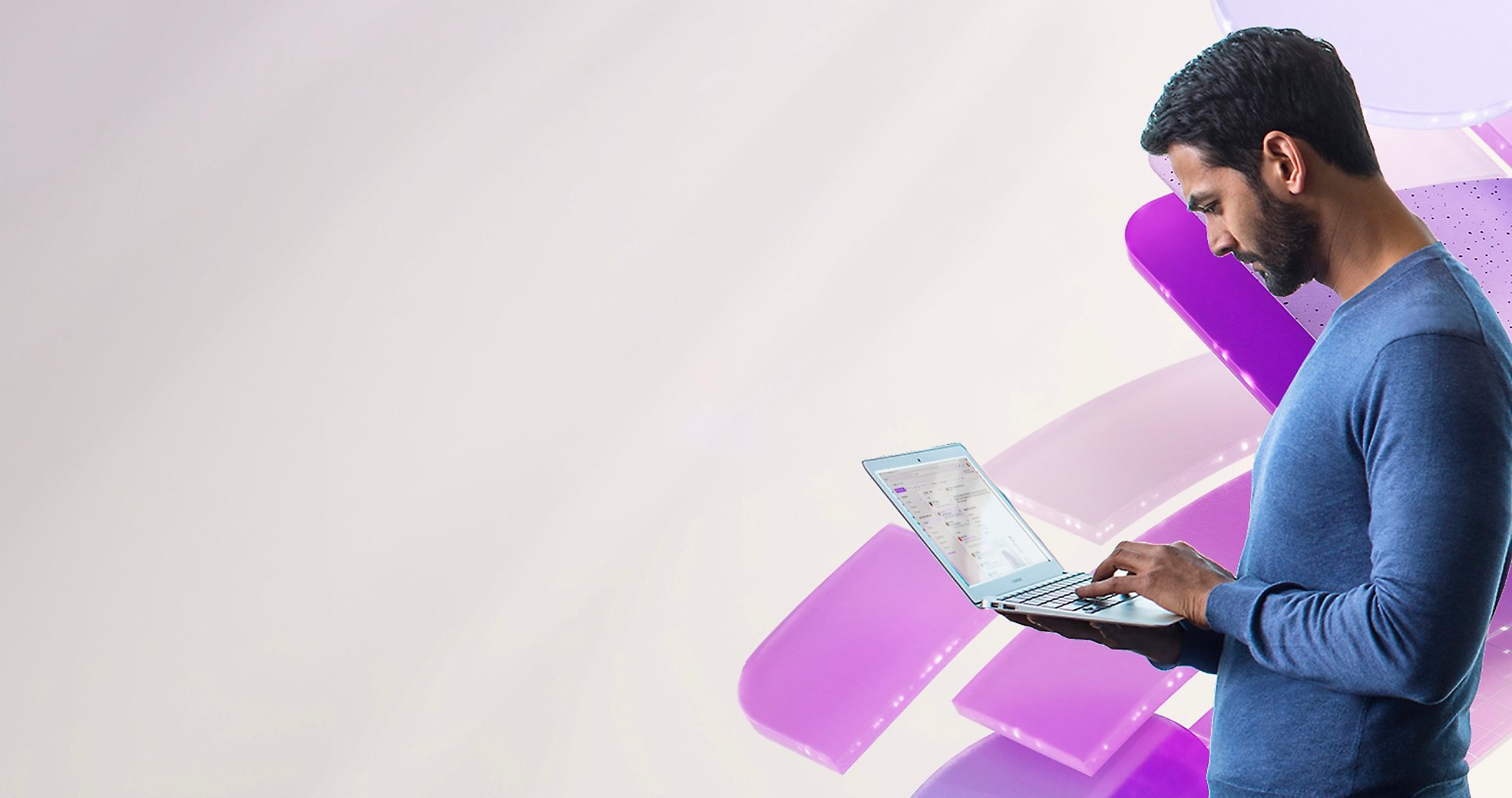 A man standing with his laptop in his arms.
