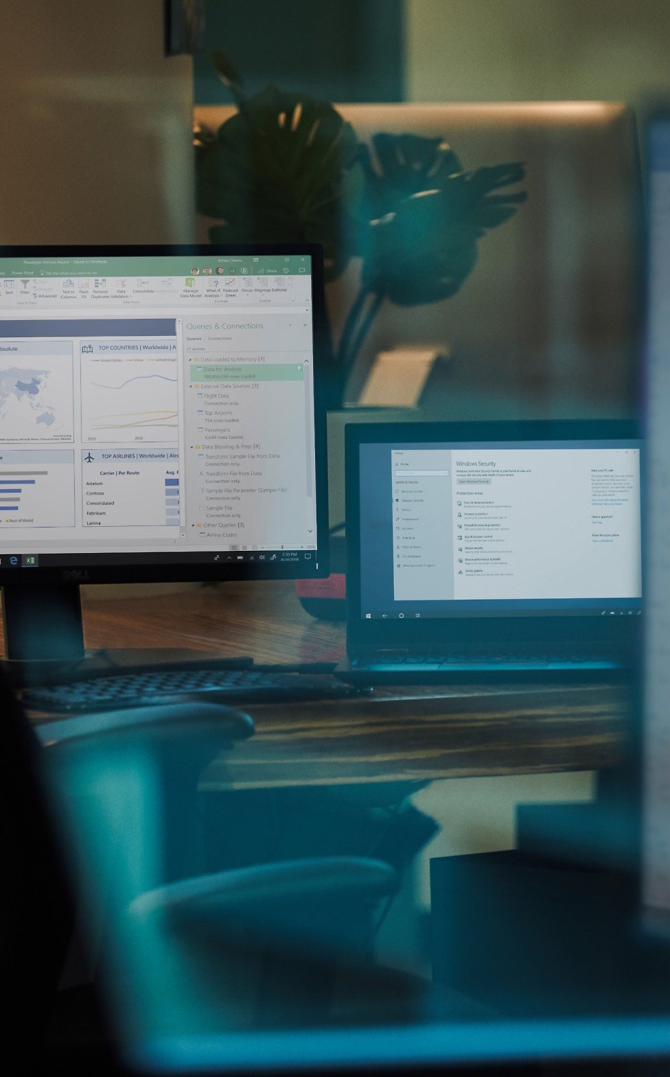 A darkened office at night with two desktop monitors showing an open mailbox.