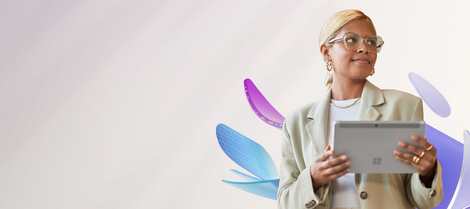 A person in a cream blazer and glasses holds a Microsoft Surface tablet.