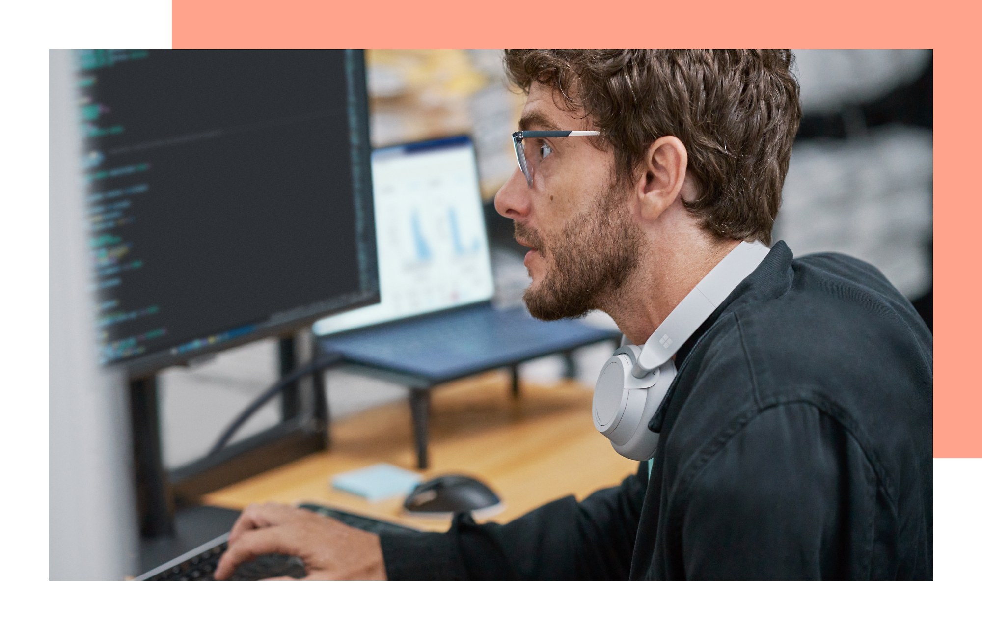 A person looking at a monitor while typing on a keyboard