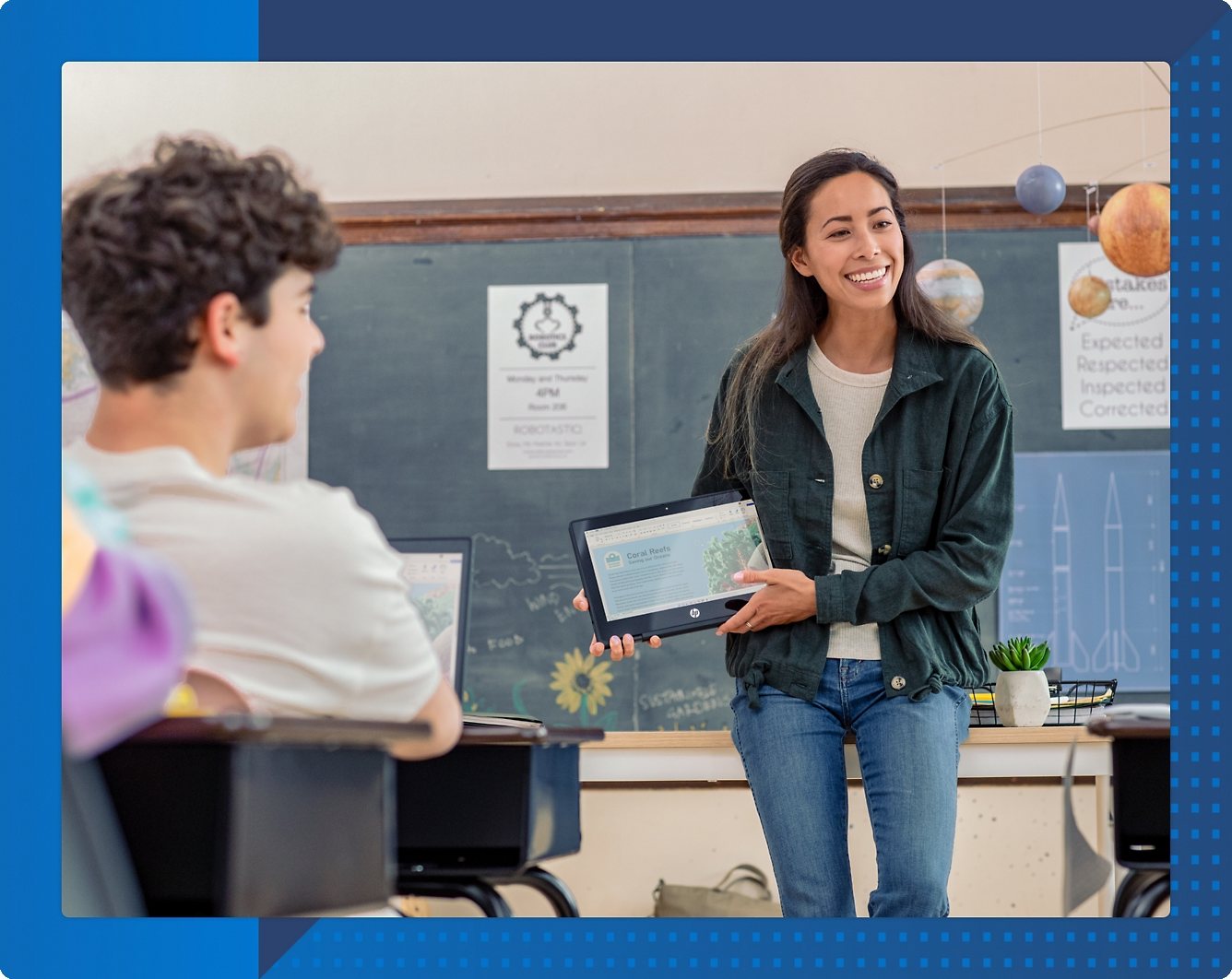 A person holding a tablet in front of a person in a classroom