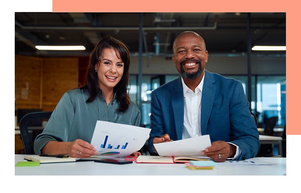 A Man and woman holding papers and smiling