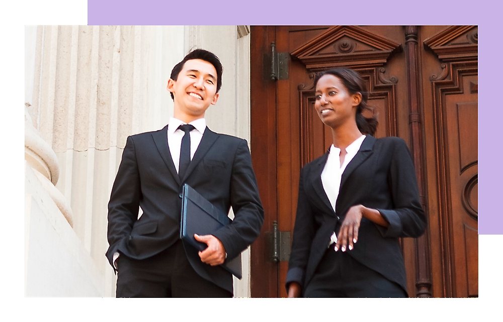 A Man and woman holding laptops and standing